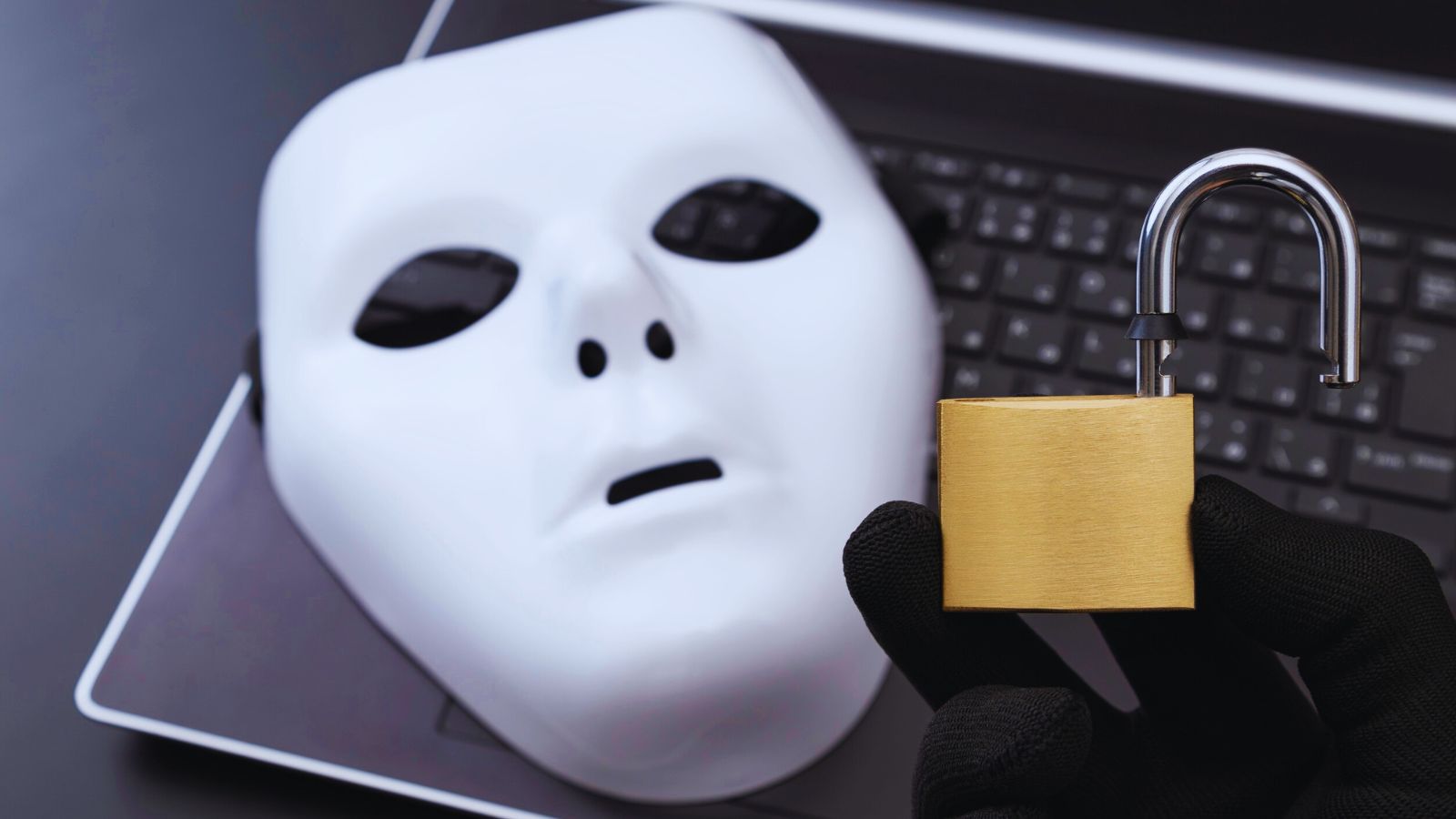 Image shows a mask on a laptop and an open lock