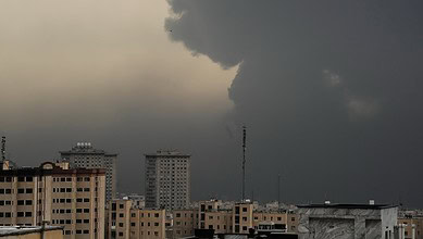 Indian nationals in Iran as dark storm clouds gather over city skyline.