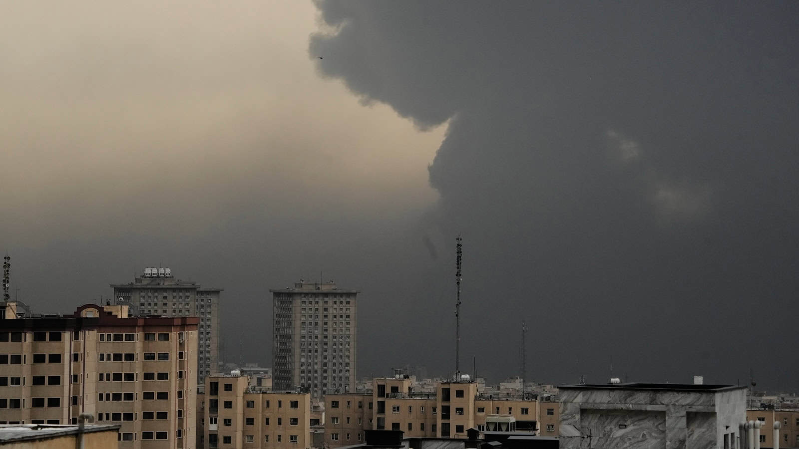 Indian nationals in Iran as dark storm clouds gather over city skyline.
