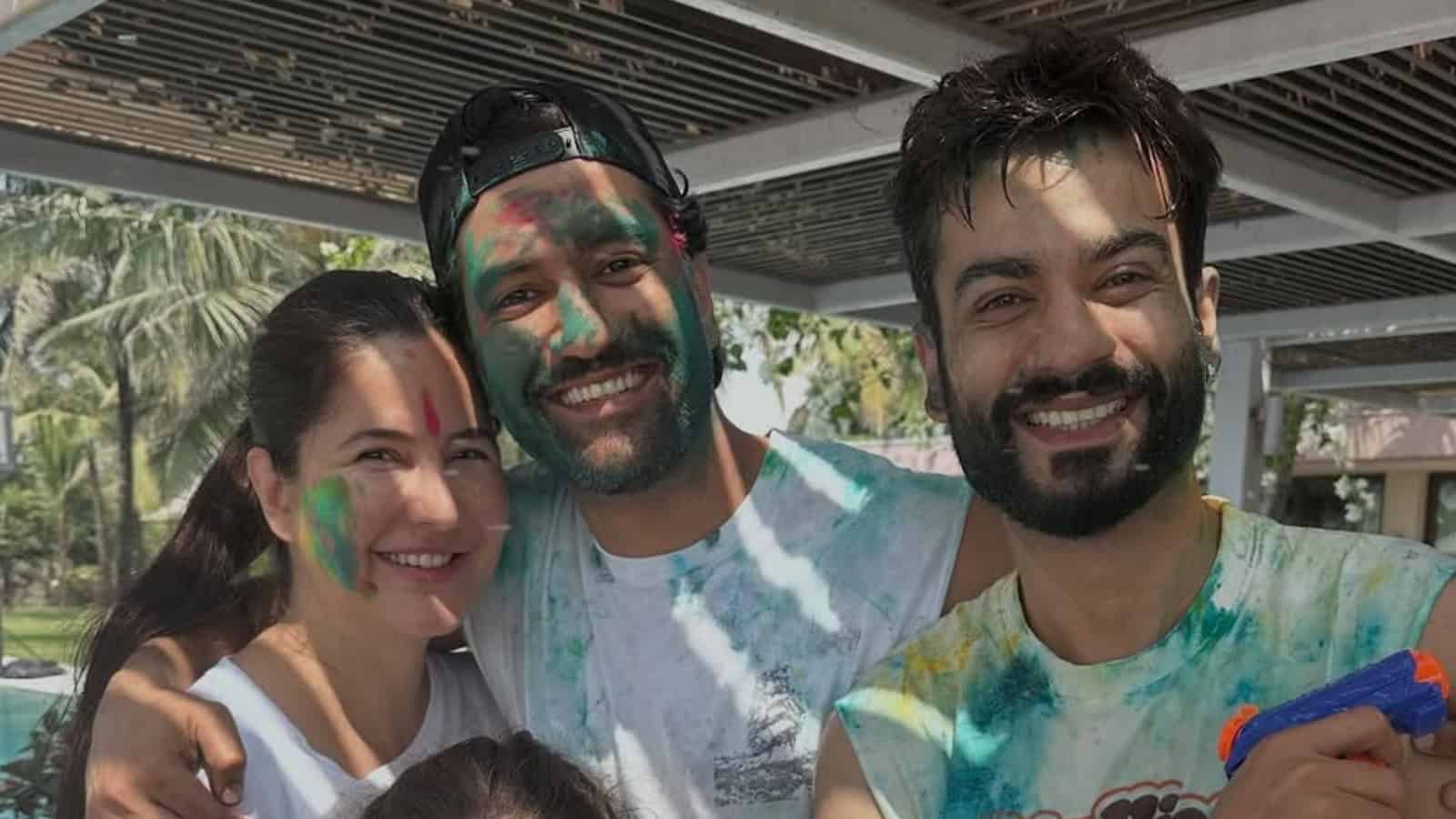 Group of friends celebrating Holi outdoors, covered in colourful powder, smiling and enjoying the festiva.