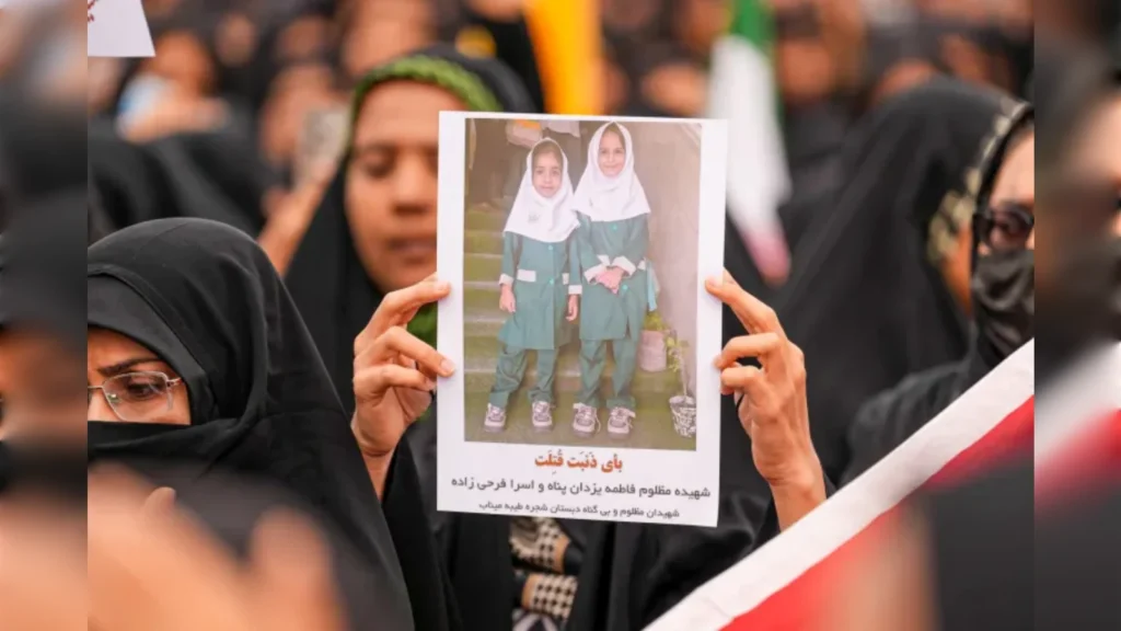 Protesters holding a photo of children in hijabs during a demonstration related to Middle East conflicts.