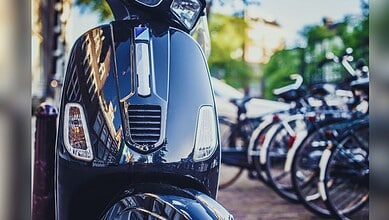 Motorcycle parked on street with bicycles in the background, reflecting urban environment and transportat.