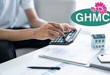 A person calculating property tax benefits with documents, a calculator, and a house model, highlighting GHMC's 90% interest rebate on property tax filed before March 31.