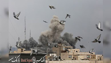 Birds fly over buildings in Tehran as a large plume of smoke rises following explosions during US and Israeli strikes on Iran.