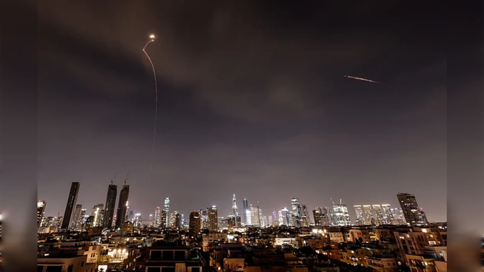 Missile interception streaks light up night sky over Tel Aviv during Iran conflict.
