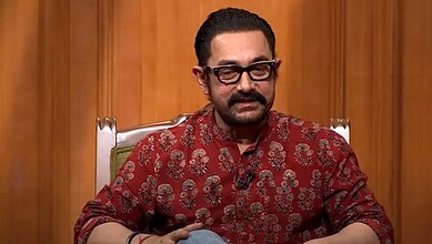 Khaled Hosseini, author, in an interview at Siasat Daily, wearing a red patterned shirt and glasses.