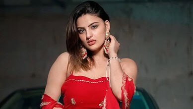 Portrait of Divyanka Sirohi, a Haryanvi actress, wearing a red outfit with earrings.