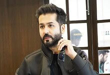 Aditya Dhar, filmmaker and writer, captured during a promotional event, showcasing his confident personal.