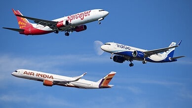 Three commercial airplanes flying in clear blue sky, representing Indian airlines facing fuel cost challe.