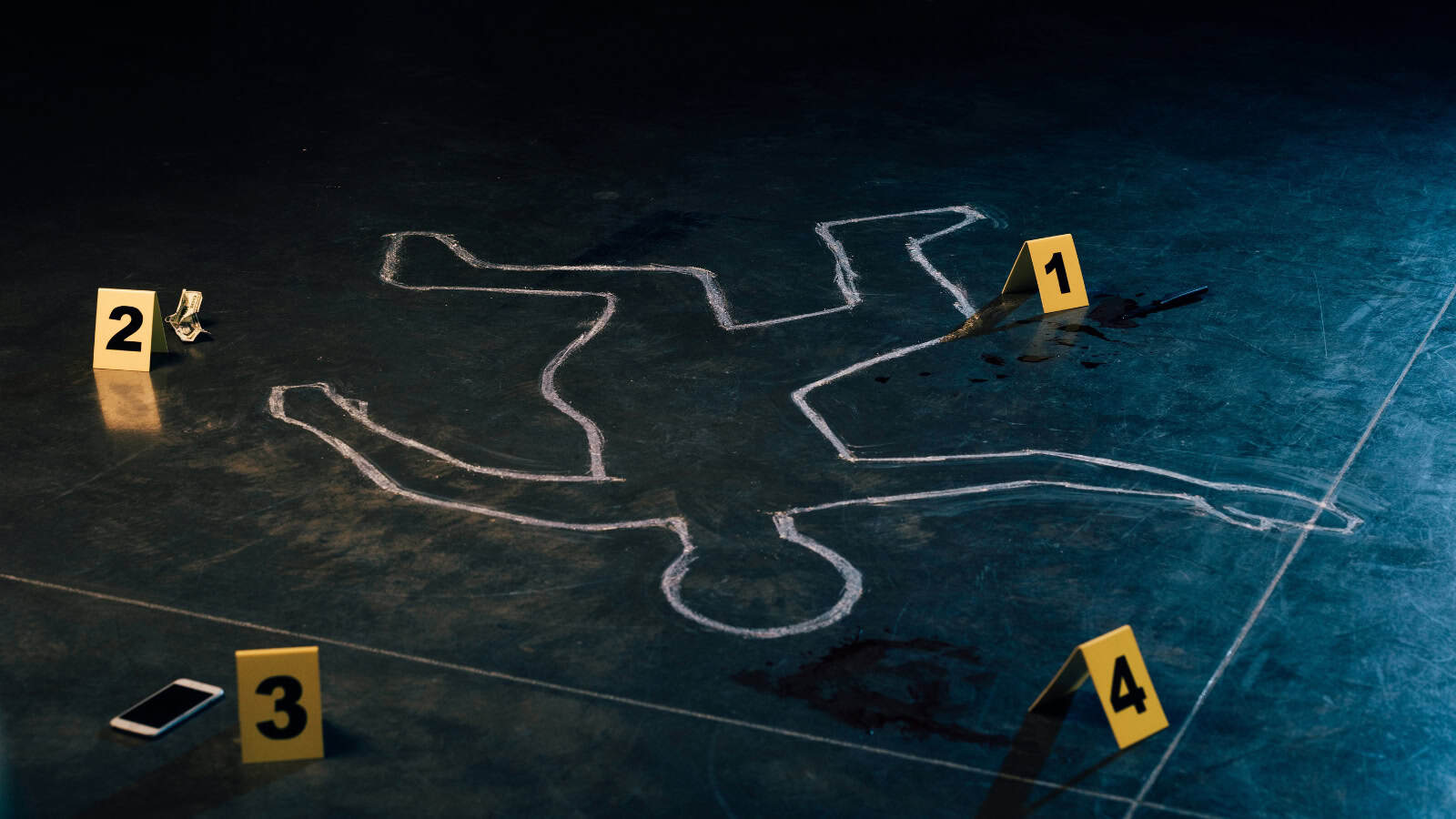 Chalk outline of a body on the ground with evidence markers, indicating a crime scene in Telangana.