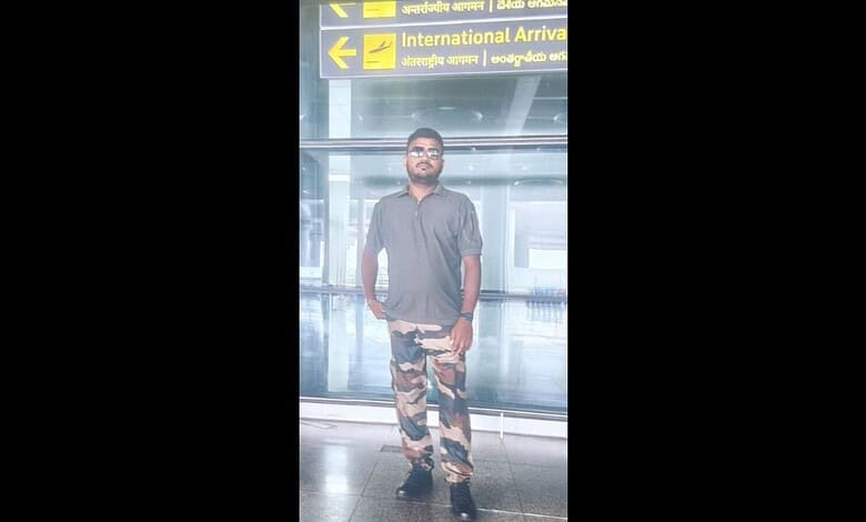 Man posing as CISF officer at Hyderabad airport, taking photos, with airport signage in background.