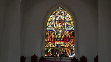 A detailed view of a stained glass window in a historic Hyderabad church highlighting its colourful craftsmanship and architectural beauty.