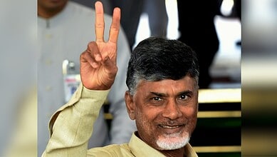 Andhra Pradesh Chief Minister holding up a peace sign at an award ceremony.