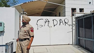 A police official stands guard after AAP workers allegedly wrote 'Gaddar', a traitor, with spray paint on the entrance gate of Rajya Sabha MP Harbhajan Singh, a day after he quit the former party and joined the BJP, in Jalandhar, Punjab, Saturday, April 25.
