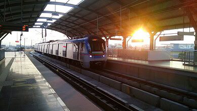 Modern Hyderabad Metro train at the station during sunset.