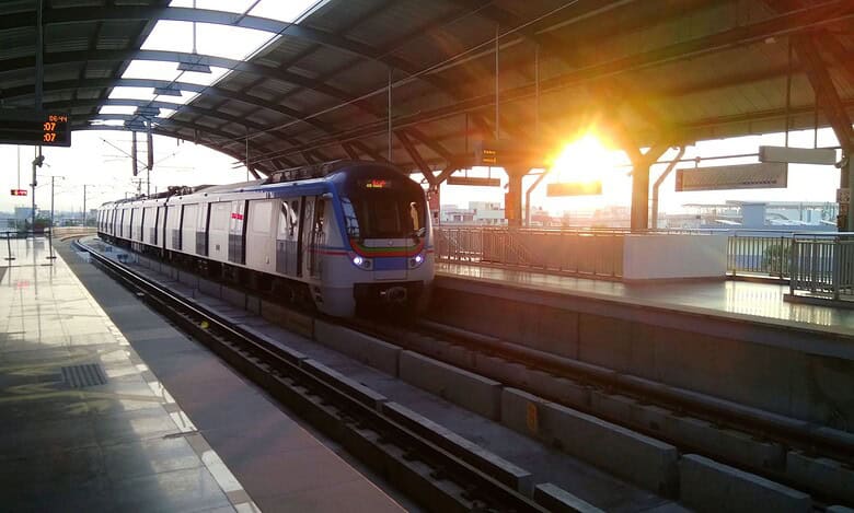 Modern Hyderabad Metro train at the station during sunset.