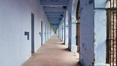 Long blue corridor at Hyderabad Police station with barred windows and doors.