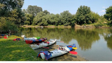 Kayaking and canoeing kayaks with paddles on the riverbank, ready for water sports in Hyderabad.