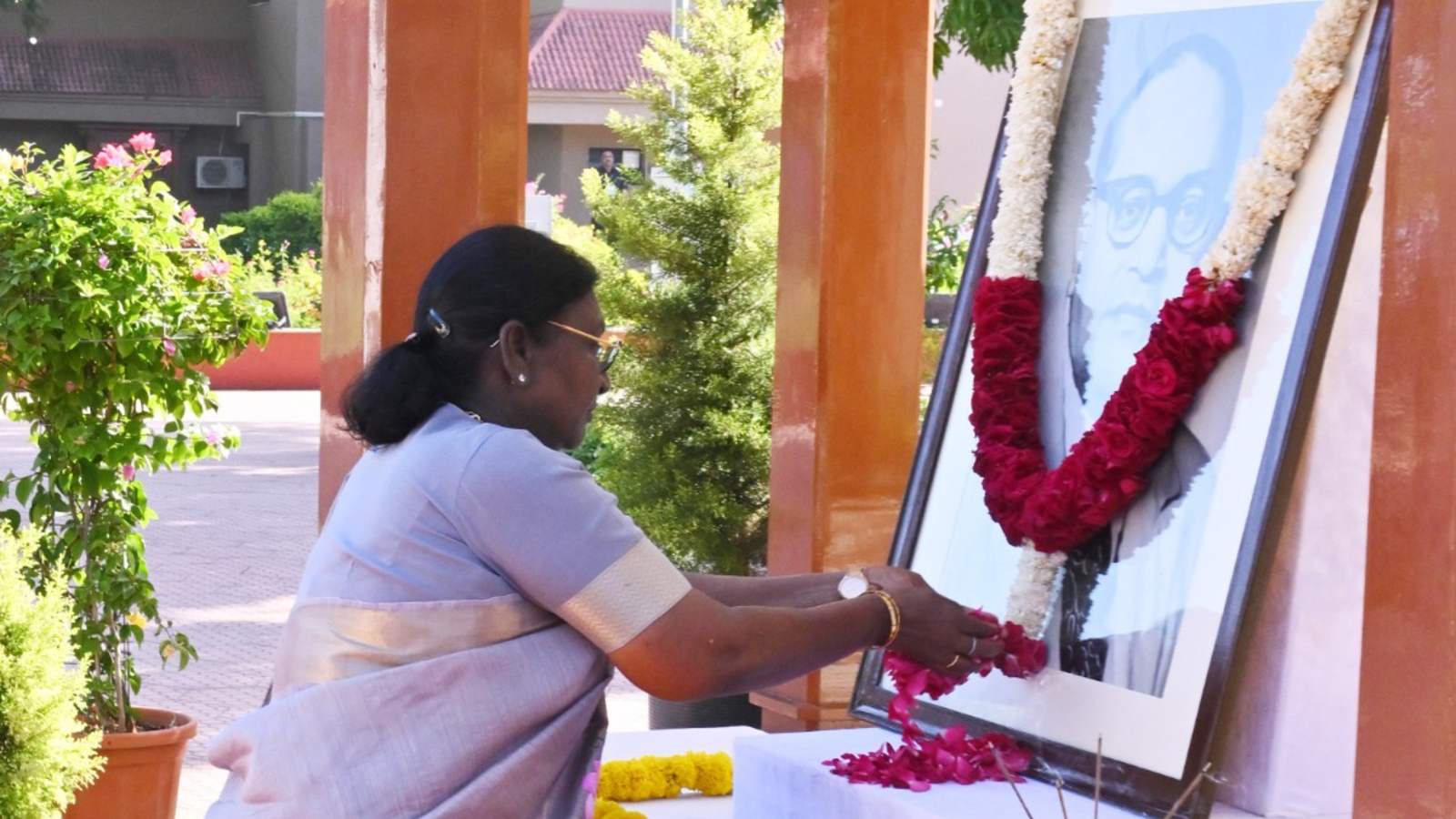 President Murmu offering flowers at a portrait of B R Ambedkar during his birth anniversary commemoration.