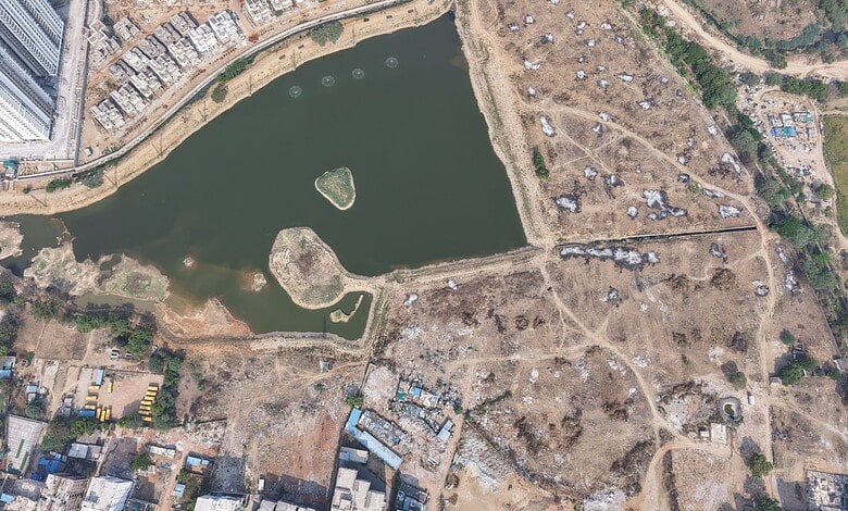 Aerial view of Muskin Cheruvu FTL with dry areas and water body, as Hydraa demands residents vacate withi.
