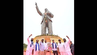 Group of people paying tribute at the Ambedkar statue in Hyderabad, highlighting respect through deeds.
