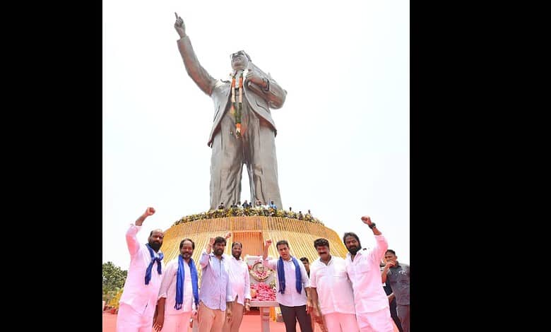 Group of people paying tribute at the Ambedkar statue in Hyderabad, highlighting respect through deeds.