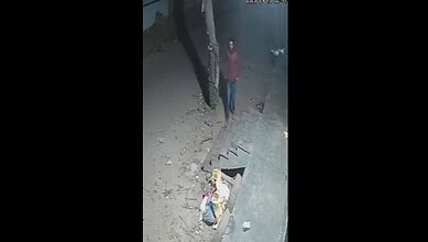 Two burglars break into a cigarette shop at night in Hyderabad, stealing stock amid a deserted street sce.