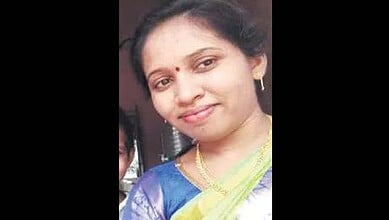 Woman Telangana police constable in traditional dress, smiling, highlighting her role and identity.