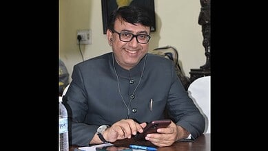Amjad Ullah Khan smiling while using a smartphone, appointed as Telangana Quresh Conference advisor.
