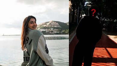 Pooja Hedge smiling by the water, with a shadowed figure of an actor in the background, hinting at their.