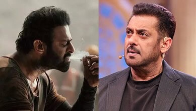 A man with a beard and dark hair smokes a cigarette, showing signs of stress and contemplation.