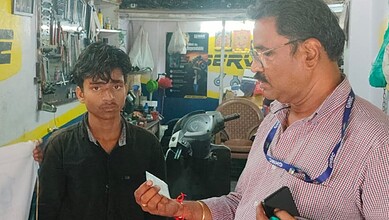 Official speaks to a young boy during a child labour awareness drive in Hyderabad.