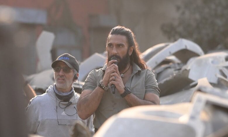BTS image of Dhurandhar speaking into a microphone on set of his upcoming film.