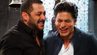 Two Bollywood actors, Salman Khan and Shah Rukh Khan, smiling and sharing a moment on set of Bhansali's f.