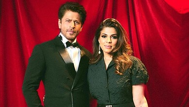 SRK’s manager with a woman at a red curtain event, highlighting Mumbai real estate investment.