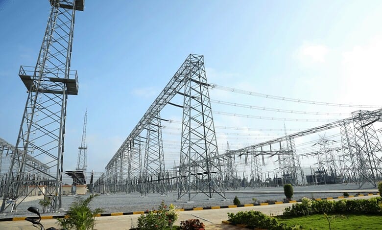 Power transmission towers and high-voltage lines at an electrical substation.