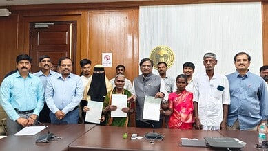 Group of officials and families receiving ex-gratia payments in Telangana.