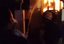 Firefighters douse the fire at Red Hills