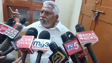 Revanth Reddy surrounded by media microphones during Telangana Congress controversy.