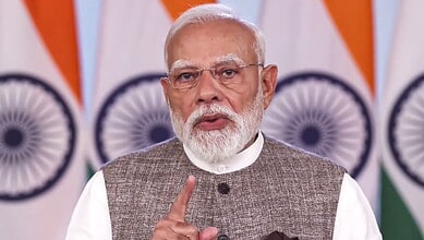 Prime Minister Modi speaking during a national address on the quota bill controversy, with Indian flags i.