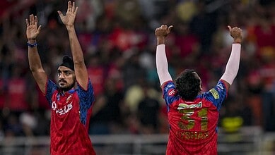 Players celebrating cricket match success with raised hands.