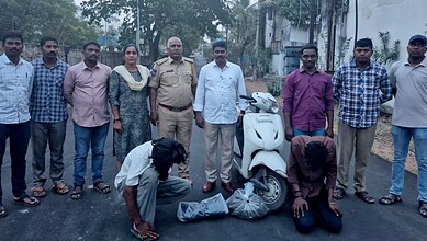 Community members and police officers inspecting seized items on a street.