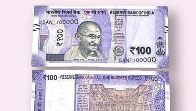 Image of a 100-rupee Indian banknote featuring Mahatma Gandhi.