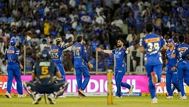 Cricket players celebrating after a successful match in a packed stadium.