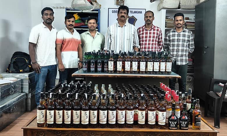 Telangana excise officials with the seized liquor