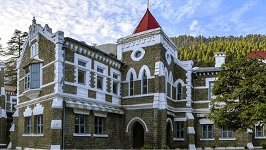 Historic stone building with red roof, under a blue sky, symbolising legal authority in child support cas.