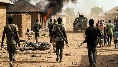 Armed militants attack a Nigerian village, setting homes on fire and causing chaos among residents.