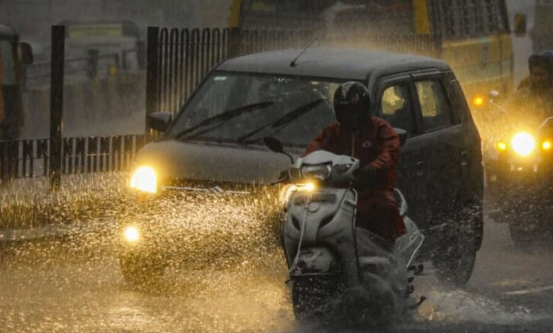 Rainy weather in Hyderabad with vehicles and pedestrians dealing with evening rains.