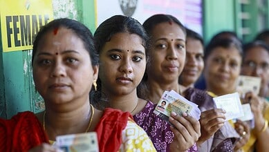 Women holding voter ID cards during election in West Bengal and Tamil Nadu.