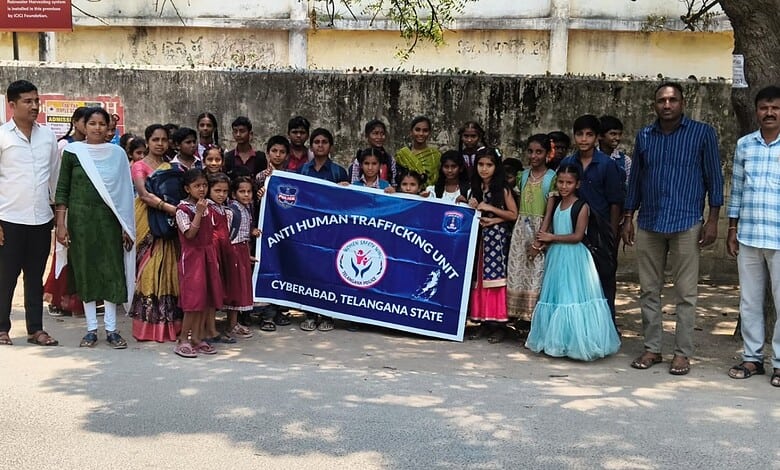 Group of children and officials holding a banner during Cyberabad decoy operation in Telangana.